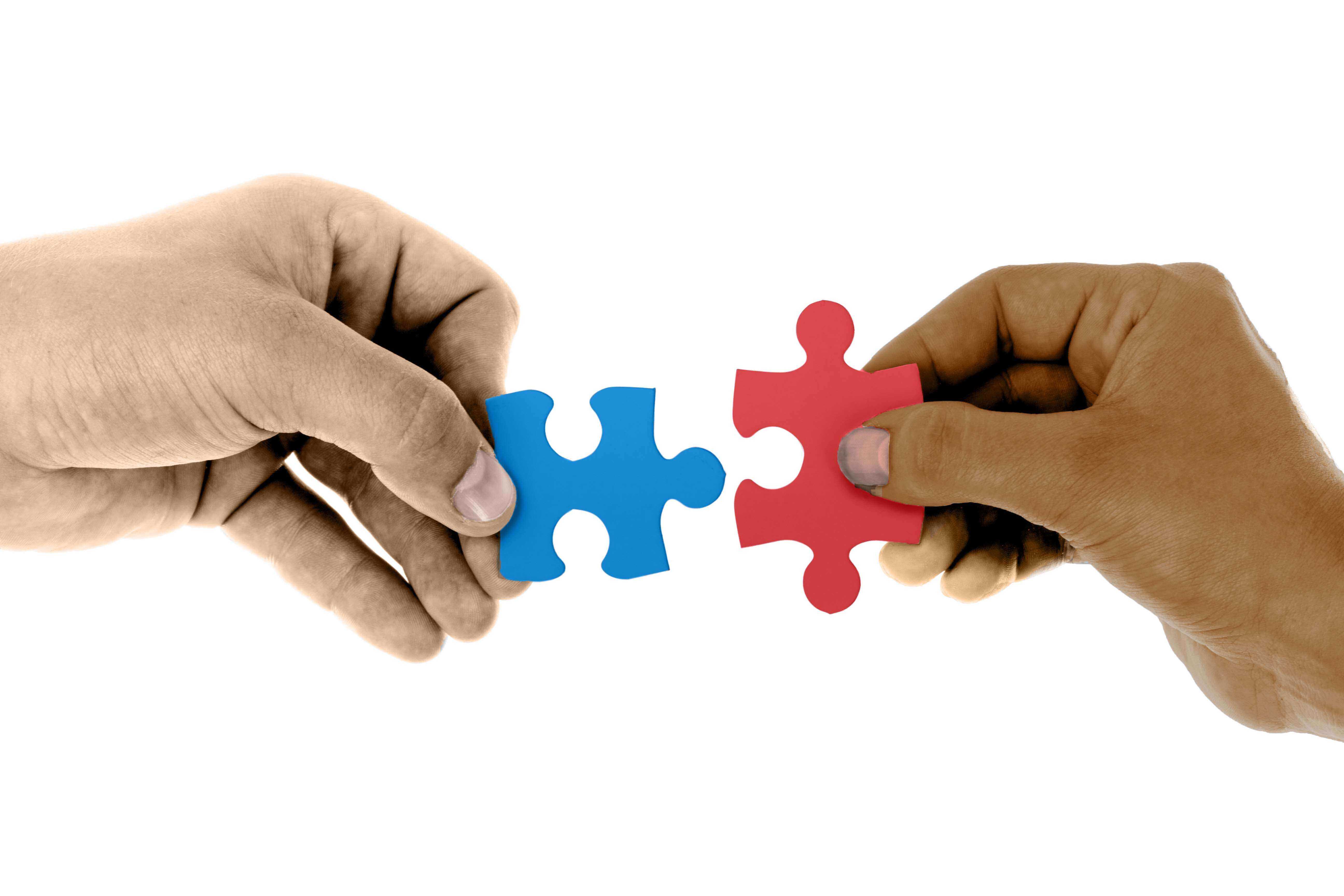 A hand on the left holding a blue puzzle piece and a hand on the right hholding a red puzzle piece